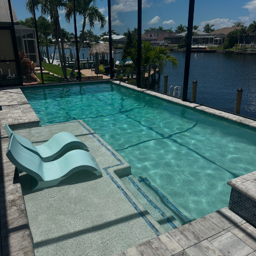 Sparkling rectangular pool with canal view and sun lounger in Cape Coral